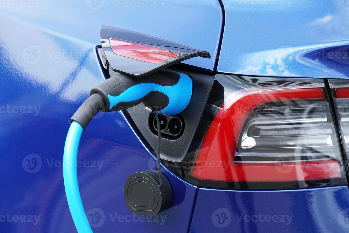 EV or Electric car at charging station with plug-in power supply cable photo