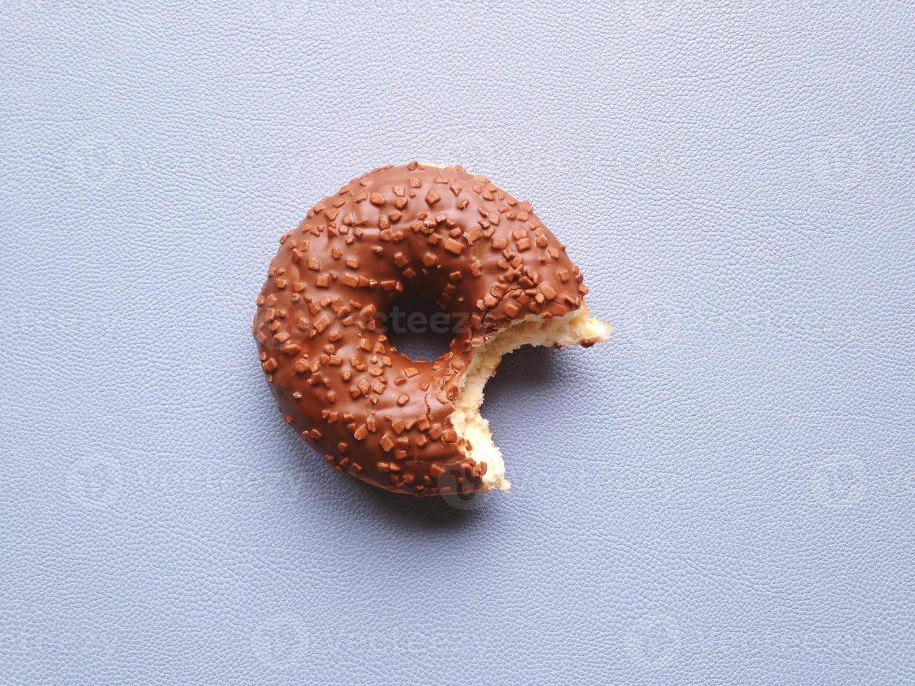 chocolate glazed donut or doughnut with bite missing photo