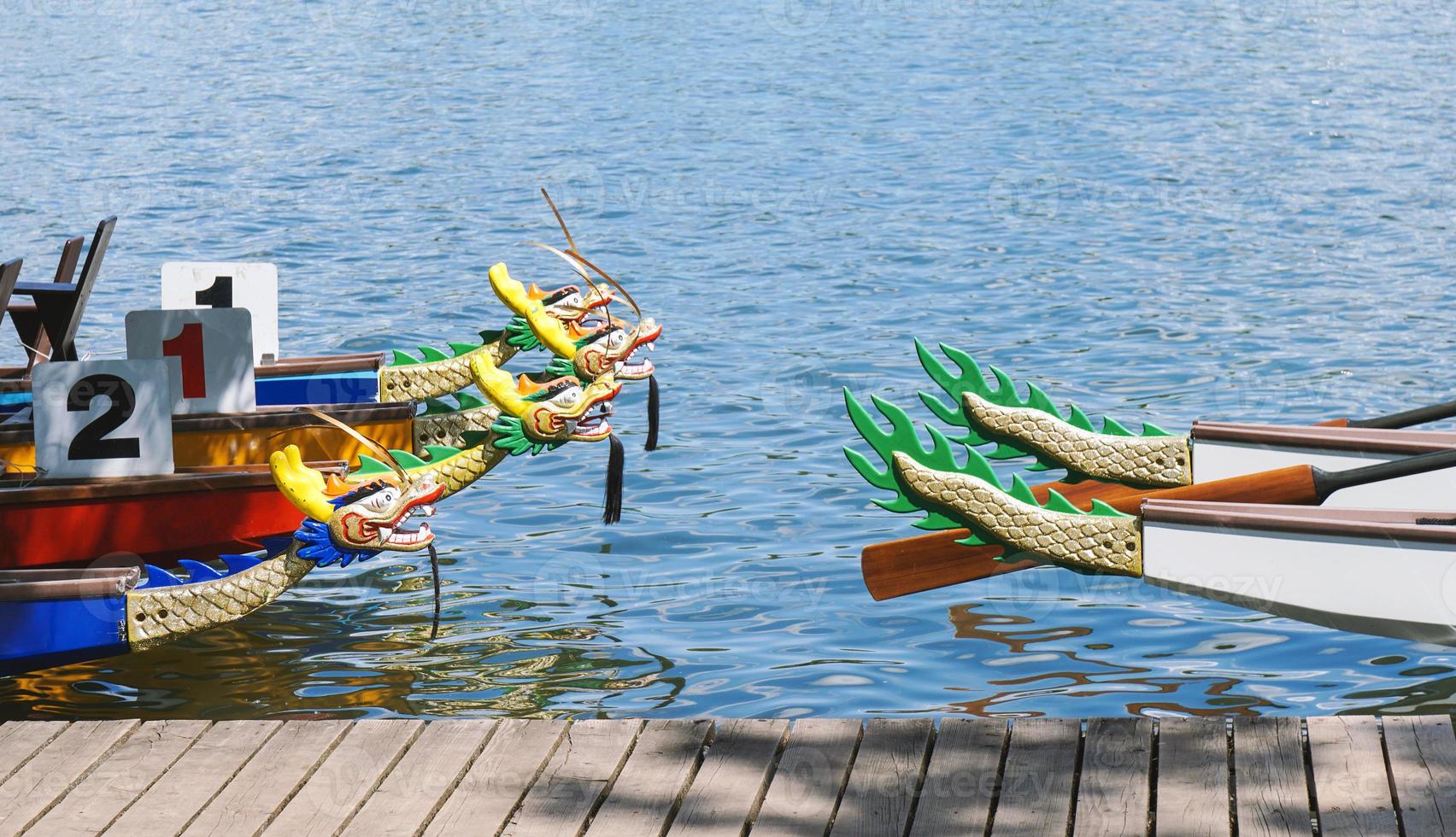 dragon boats moored at wooden jetty photo