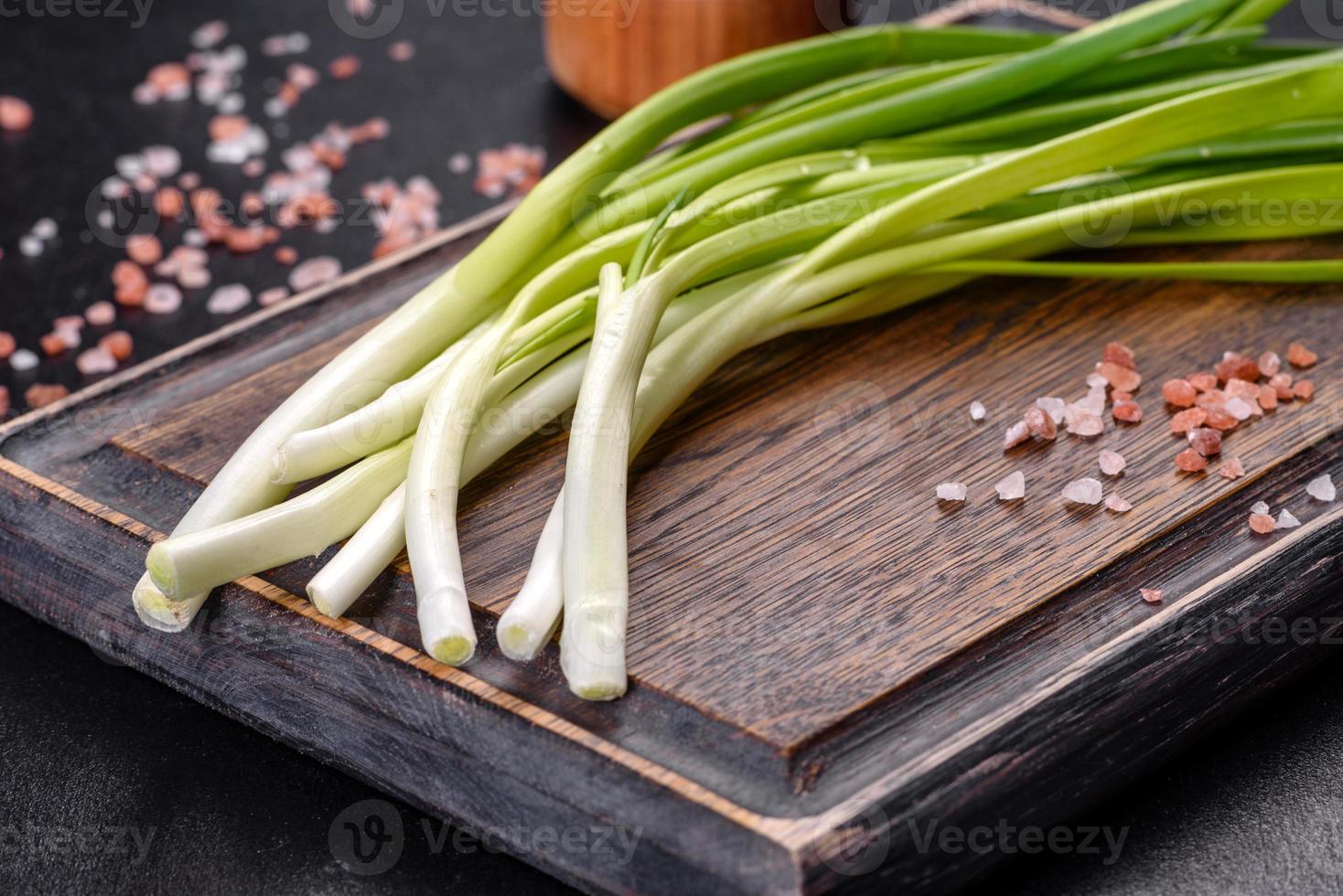 Green onion or scallion on wooden board, fresh spring chives photo