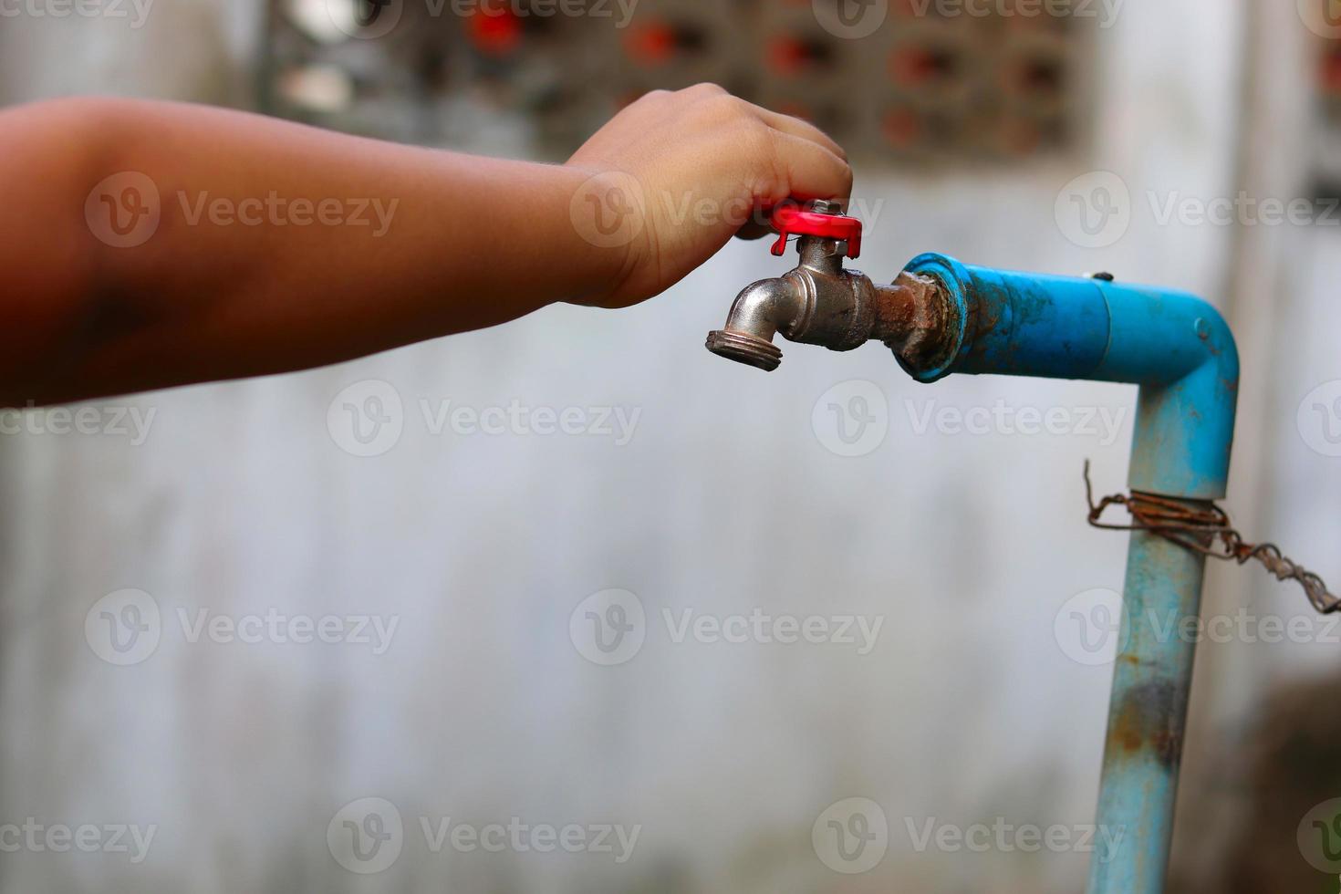 Young hand turning off water tap photo