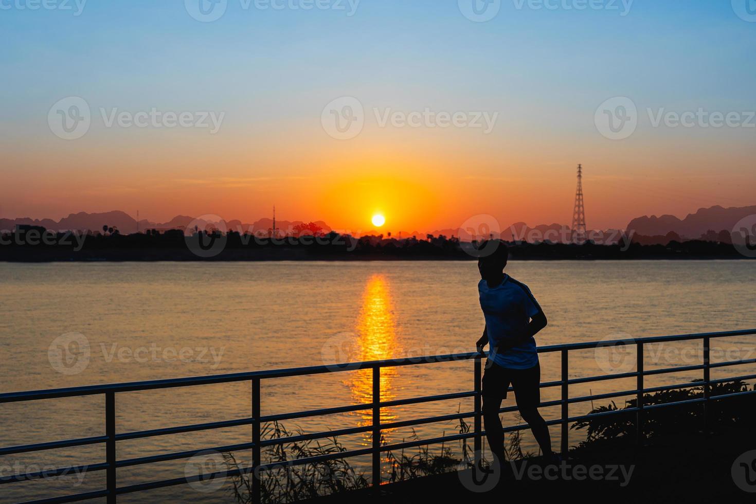 Man running on street with a view of river in the morning. photo