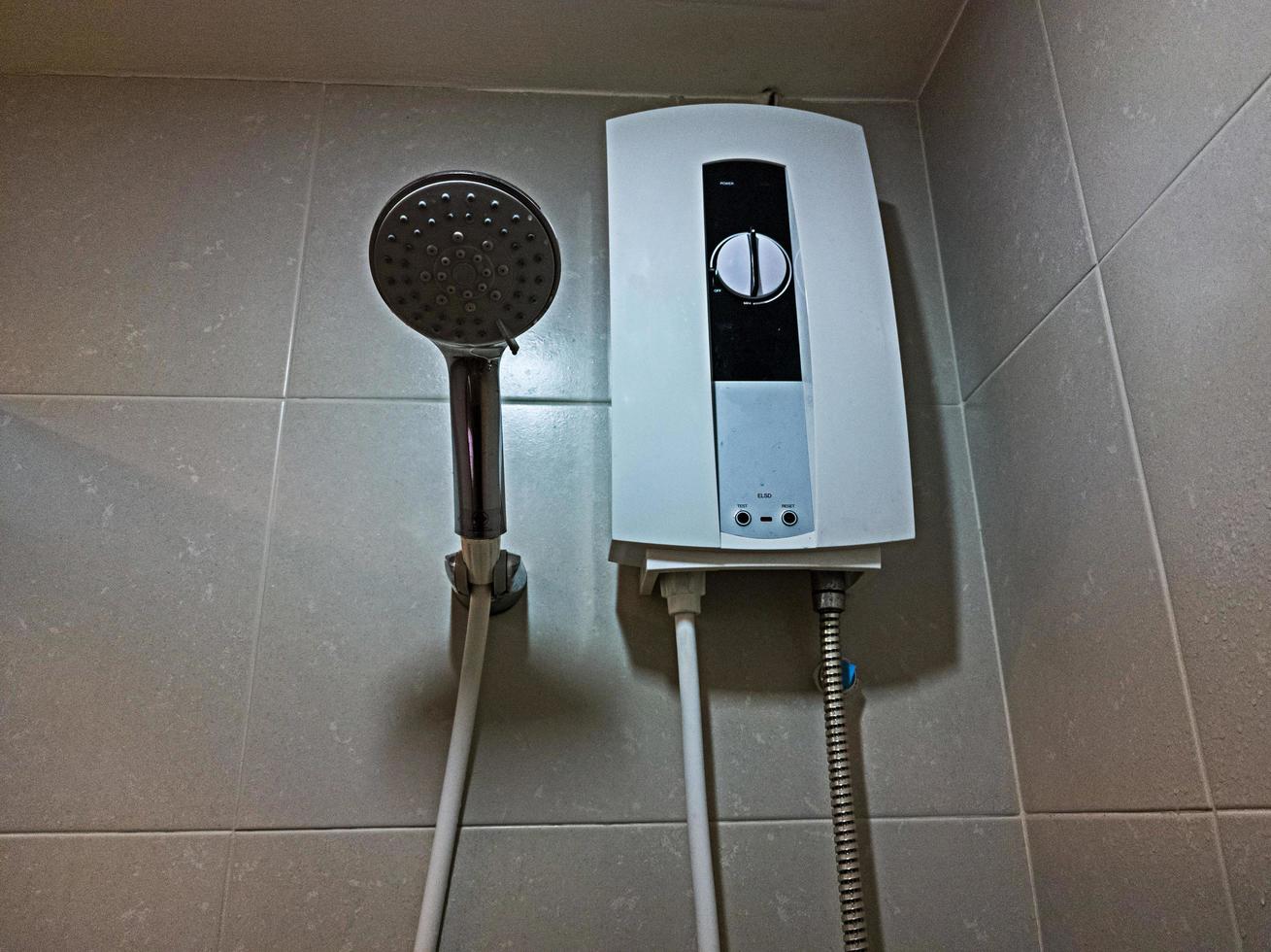 ducha y calentador de agua eléctrico en el baño foto