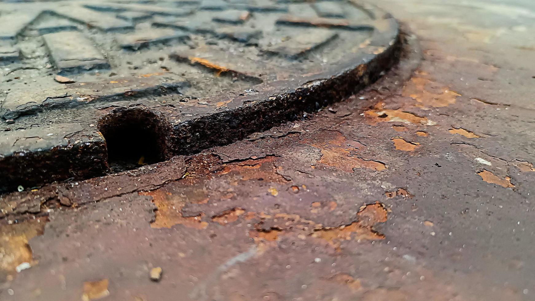 Rust on the floor next to the sewer. photo
