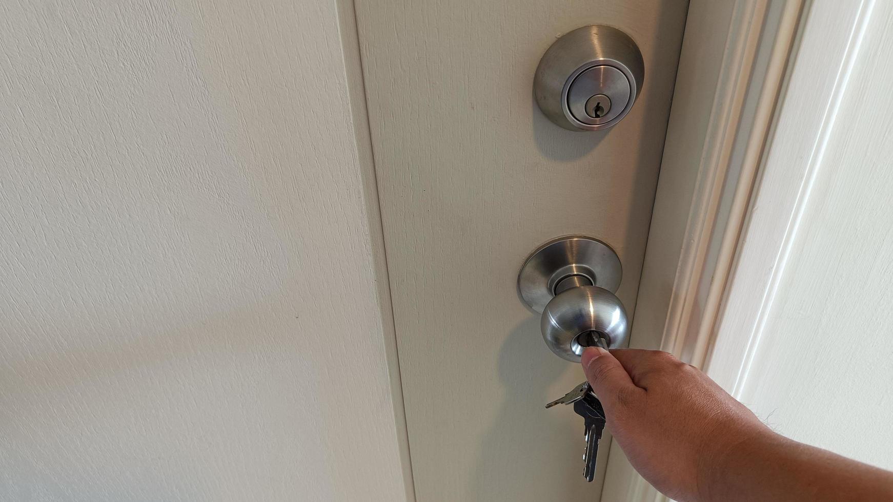 Man hand use a key for lock or unlock wooden door photo