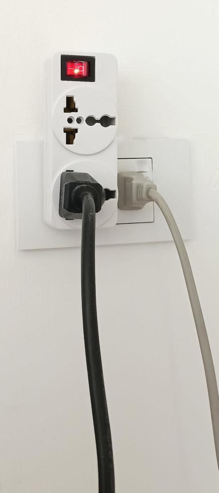 Múltiples tomas de corriente, equipos eléctricos, cables y regletas en su hogar ahorran electricidad. foto