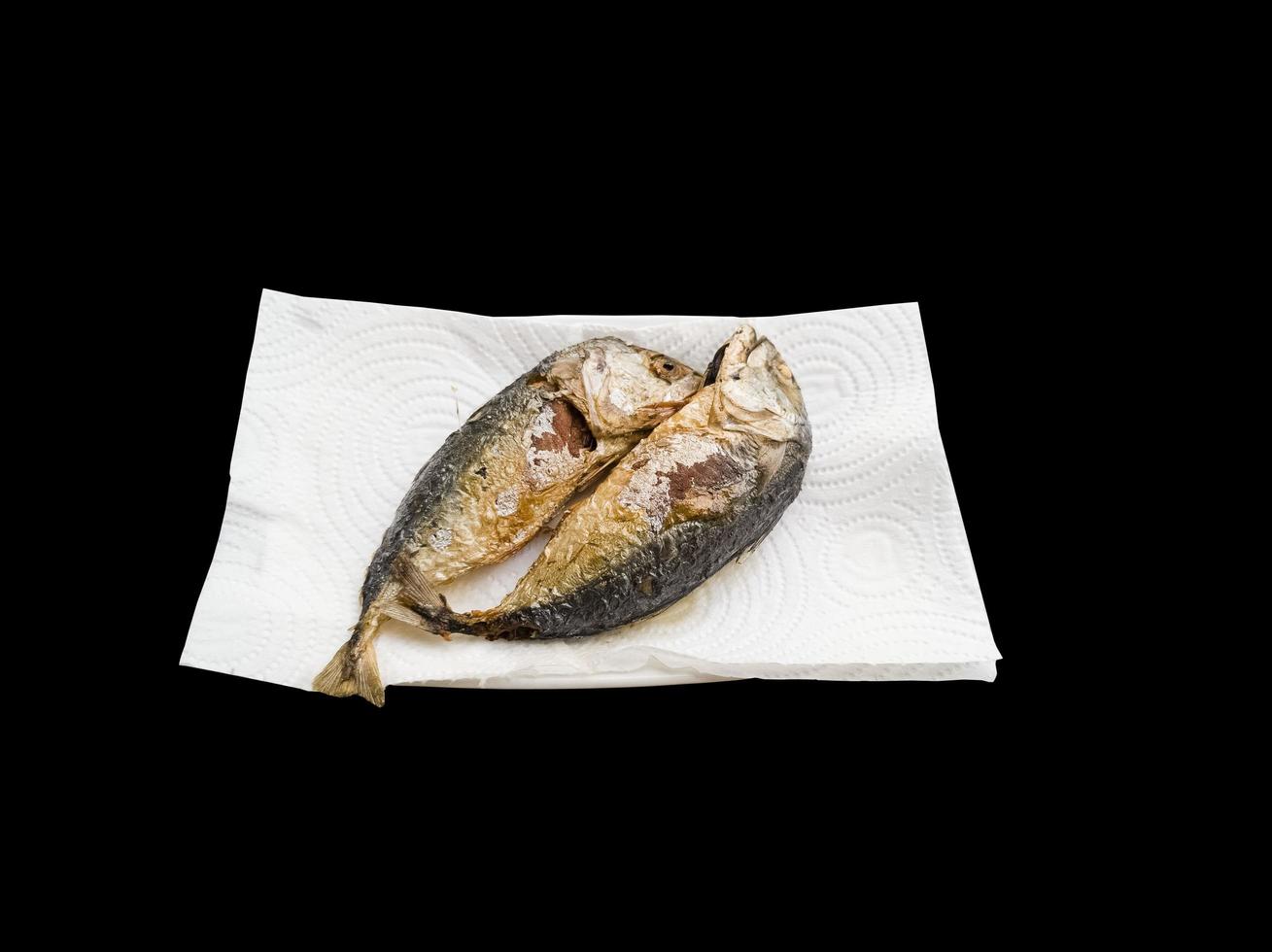 The fried mackerel is placed on tissue paper to absorb the oil. photo