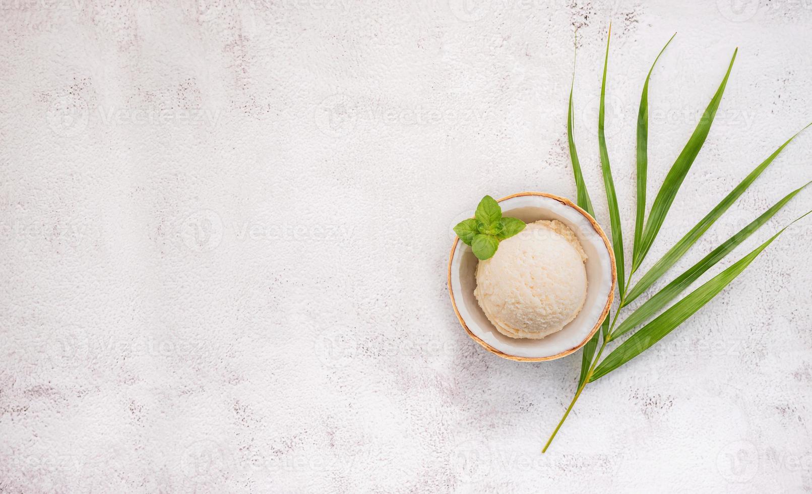 Coconut ice cream flavours in half of coconut setup on white stone background. Summer and Sweet menu concept. photo