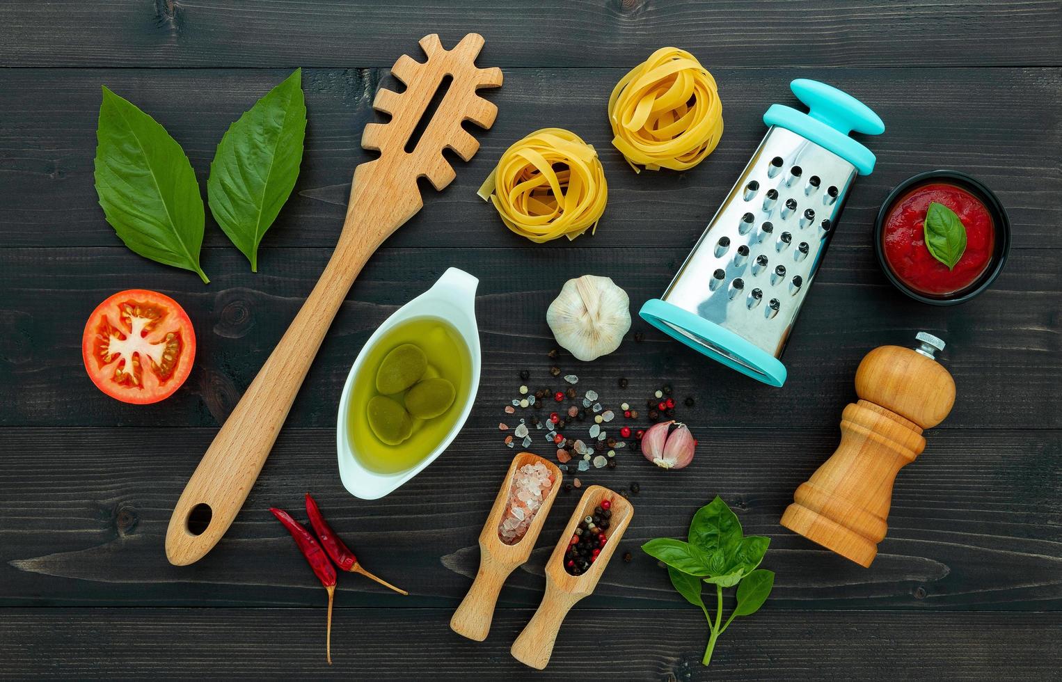 The  pasta on black wooden background. Yellow italian pasta with ingredients. Italian food and menu concept. photo