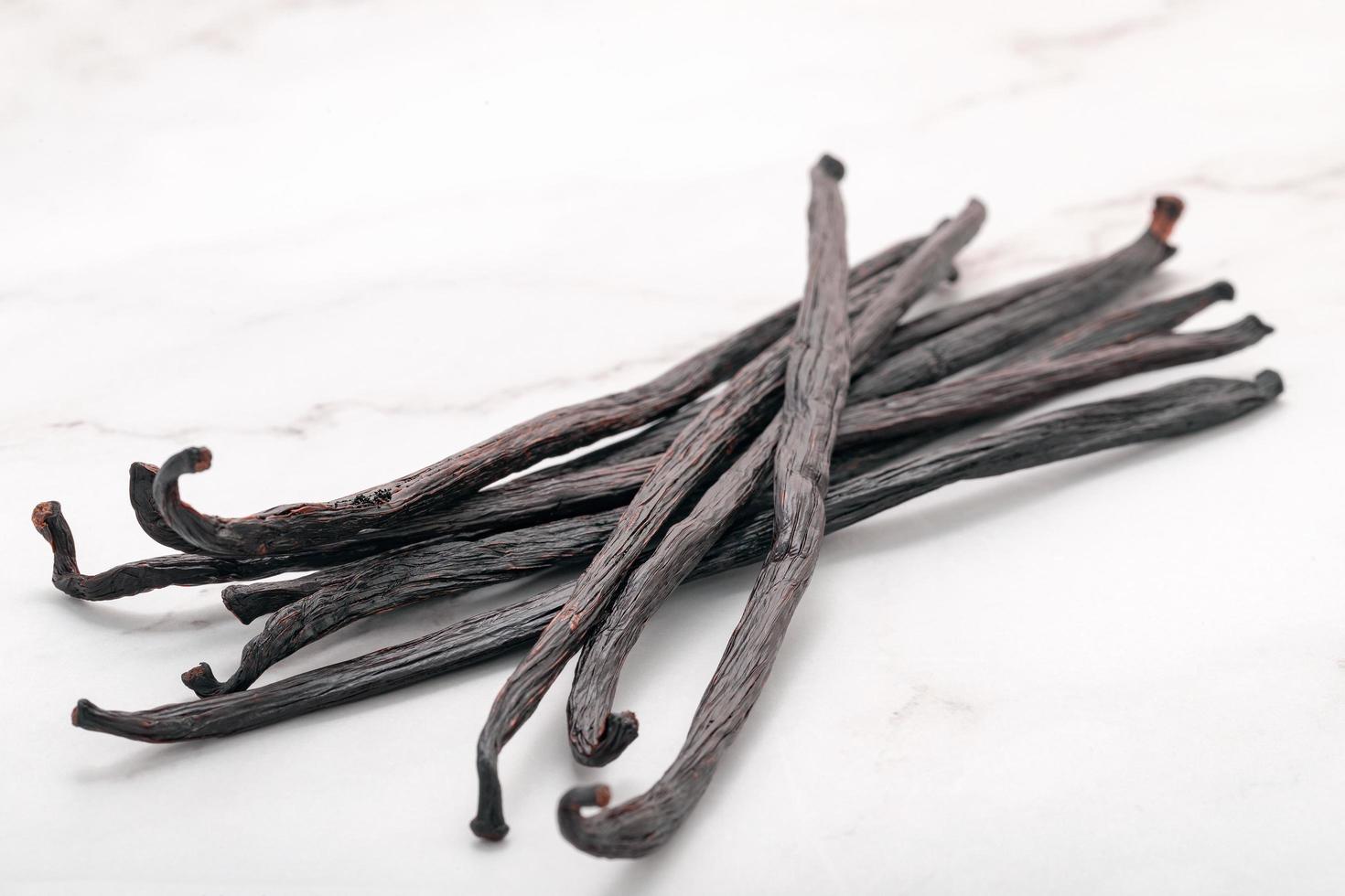 Dried vanilla sticks set up on marble background. photo