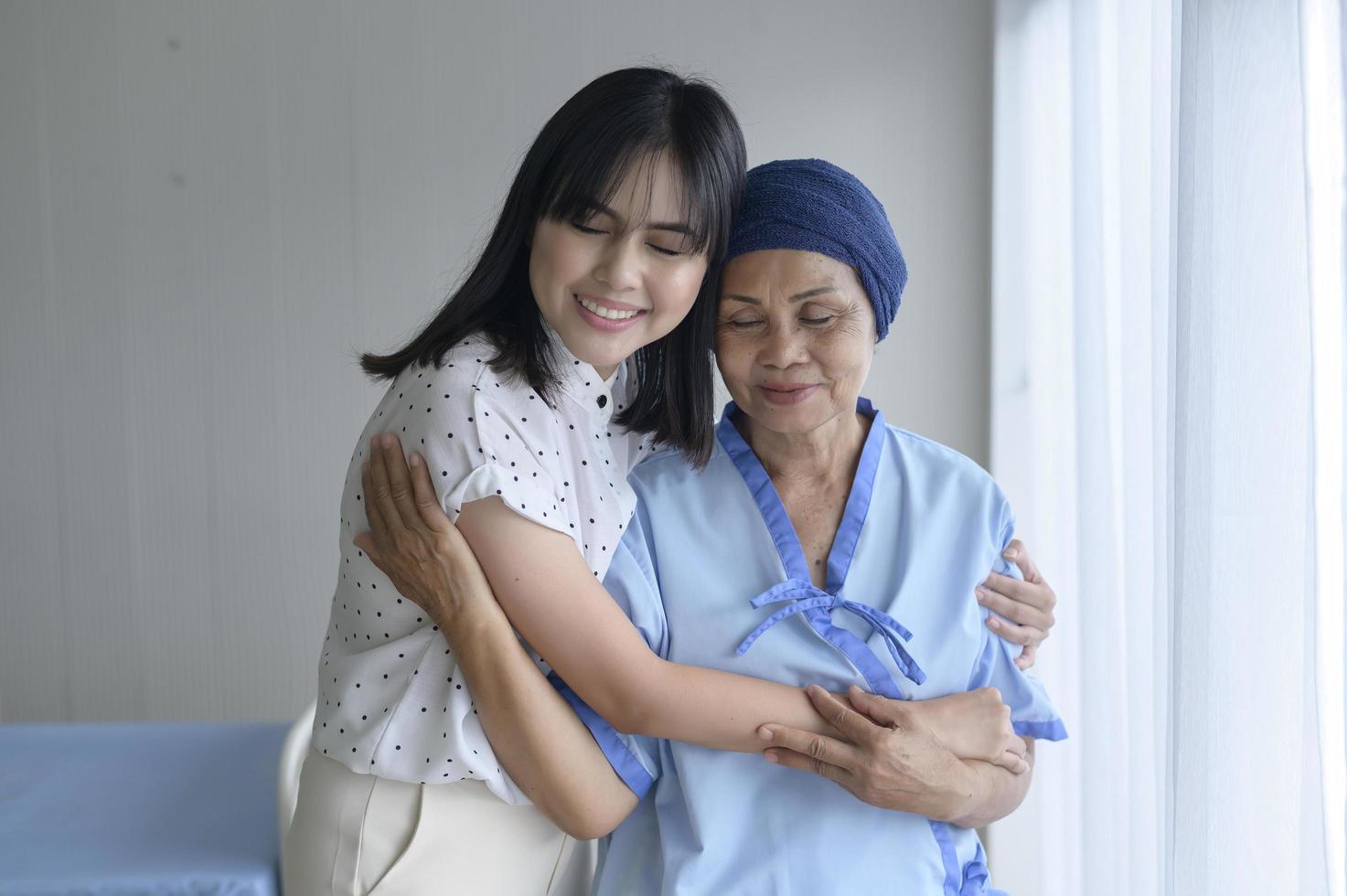 Cancer patient woman wearing head scarf and her supportive daughter in hospital, health and insurance concept. photo