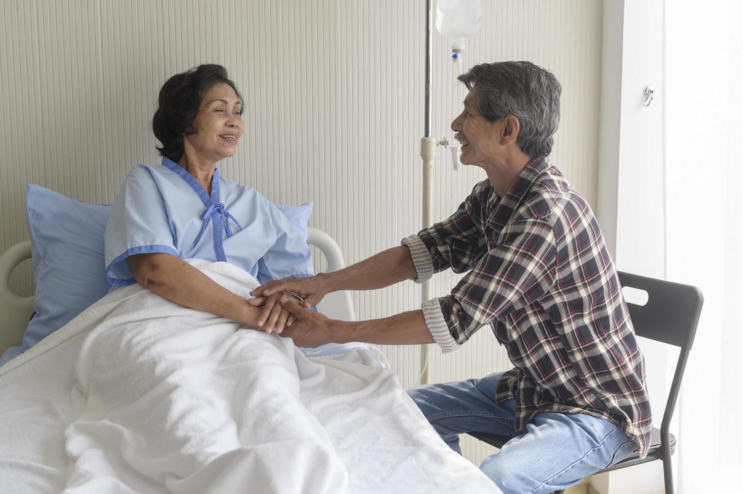 Senior man visiting senior patient woman at hospital, health care and medical concept photo