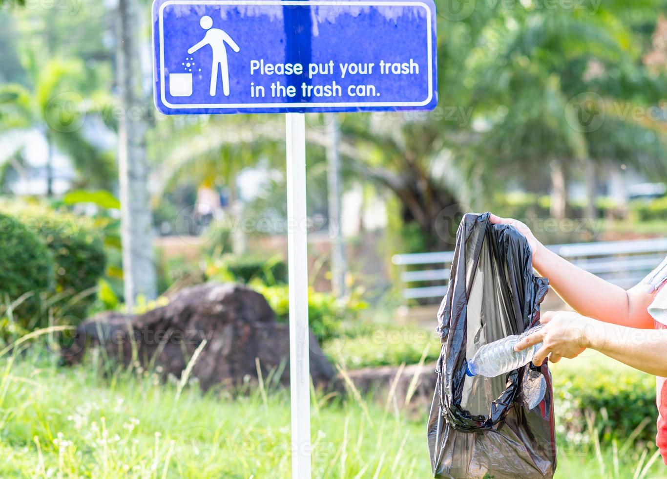 A woman cleans up by picking up plastic bottles at a natural park. Concept of protecting the environment, saving the world, recycling, reducing global warming, Earth Day. close up, blurred background photo