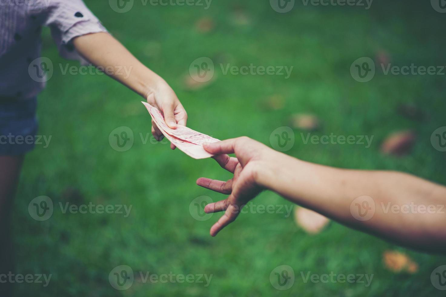 mano y dinero para pagarse unos a otros es algo bueno y debe compartir la felicidad entre ellos. dando dinero foto