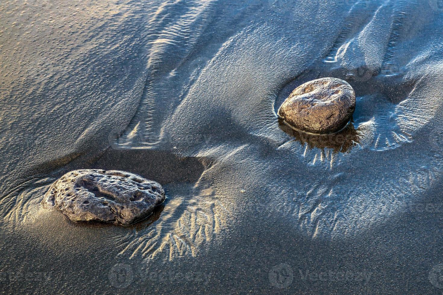 dos rocas en arena volcánica foto