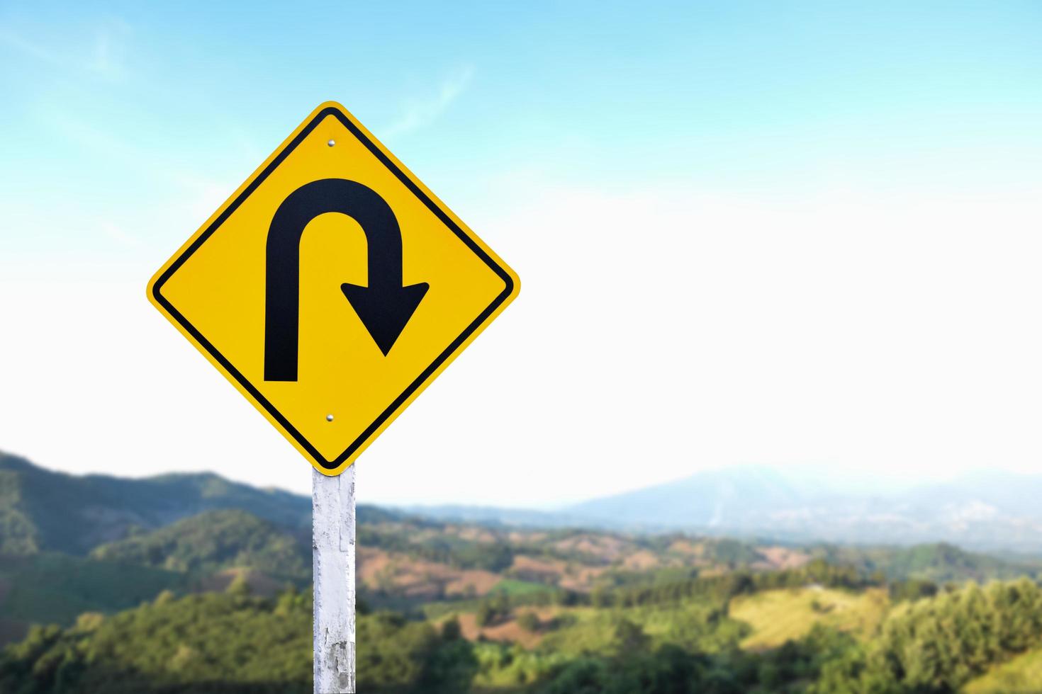 Right turn sign on white pole with clouds and blue sky background. photo