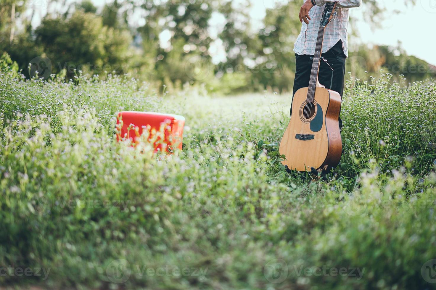 The man's hand plays the acoustic guitar, plays the guitar in the garden alone, happily and loves the music. photo