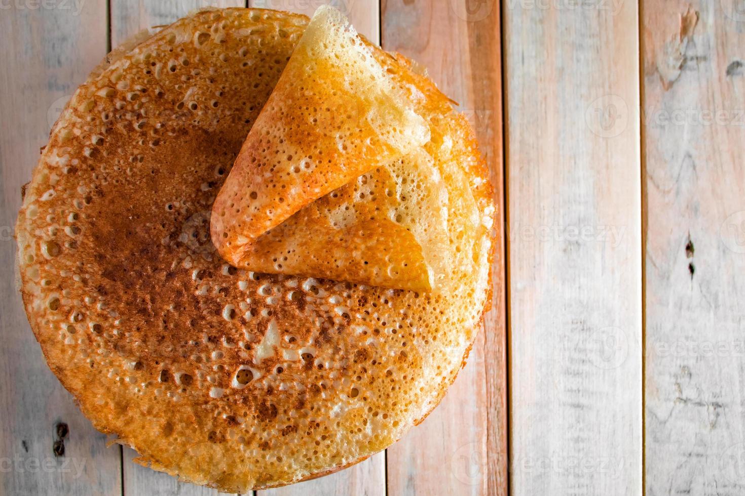 Appetizing thin pancakes on a wooden background. Russian food for the holiday Maslenitsa. photo