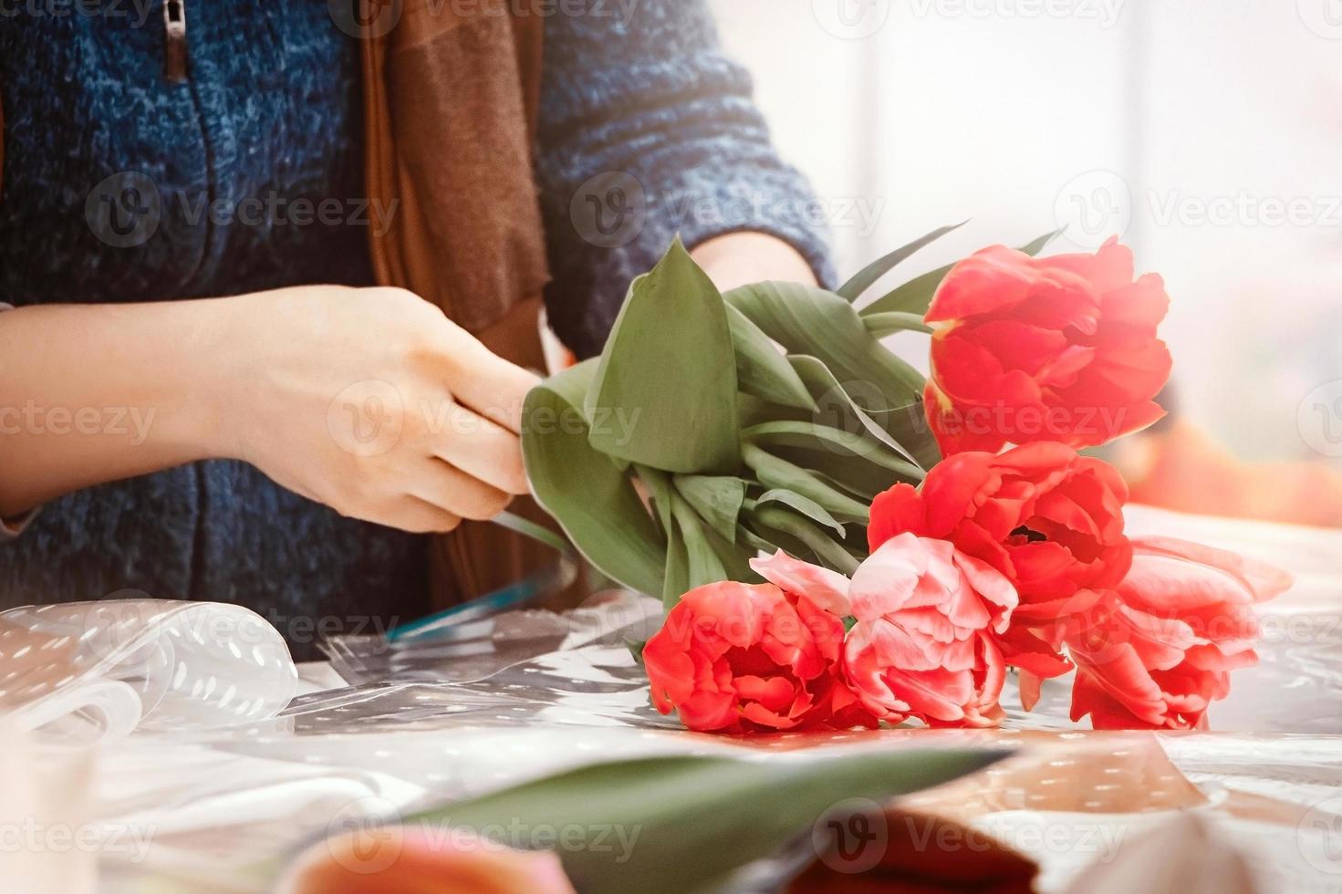 mujer florista hace ramo de tulipanes frescos. foto