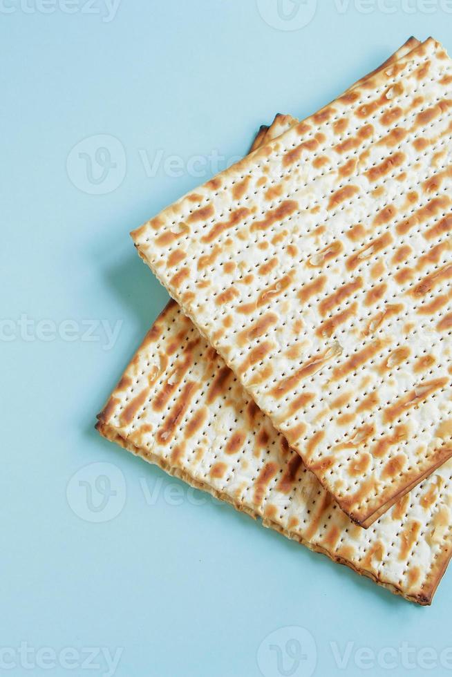 Matzo on a blue background. Happy Passover concept. Traditional Jewish food for Pesach. photo