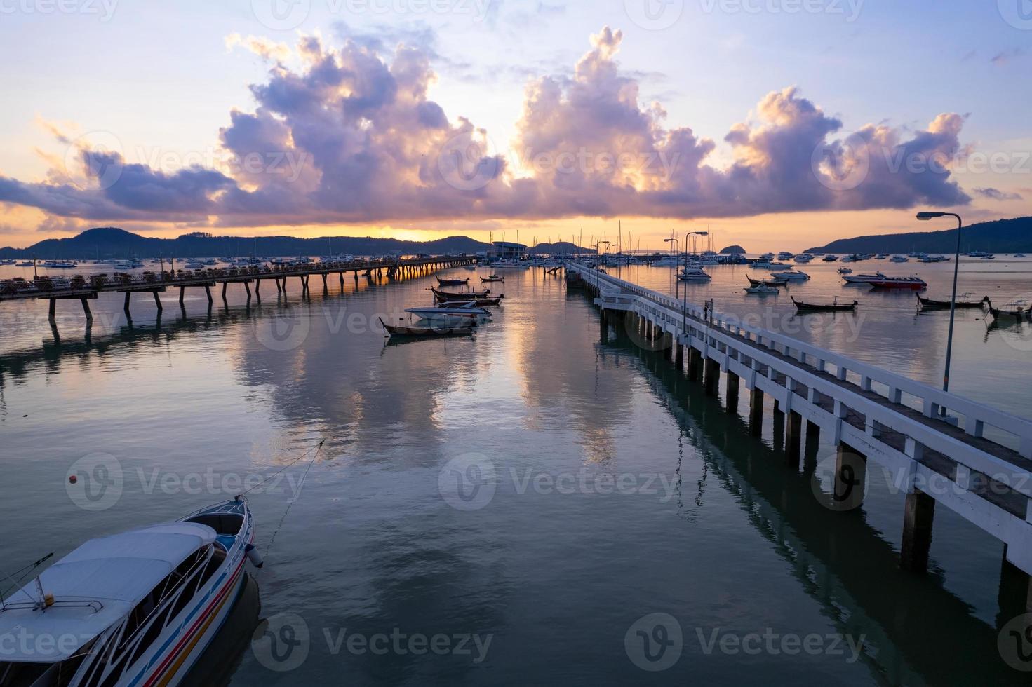 Aerial View Top down Drone shot of Yacht and sailboat parking in marina at Chalong bay Transportation and travel background concept.Beautiful sea with mountain sunrise sky clouds sunset background photo