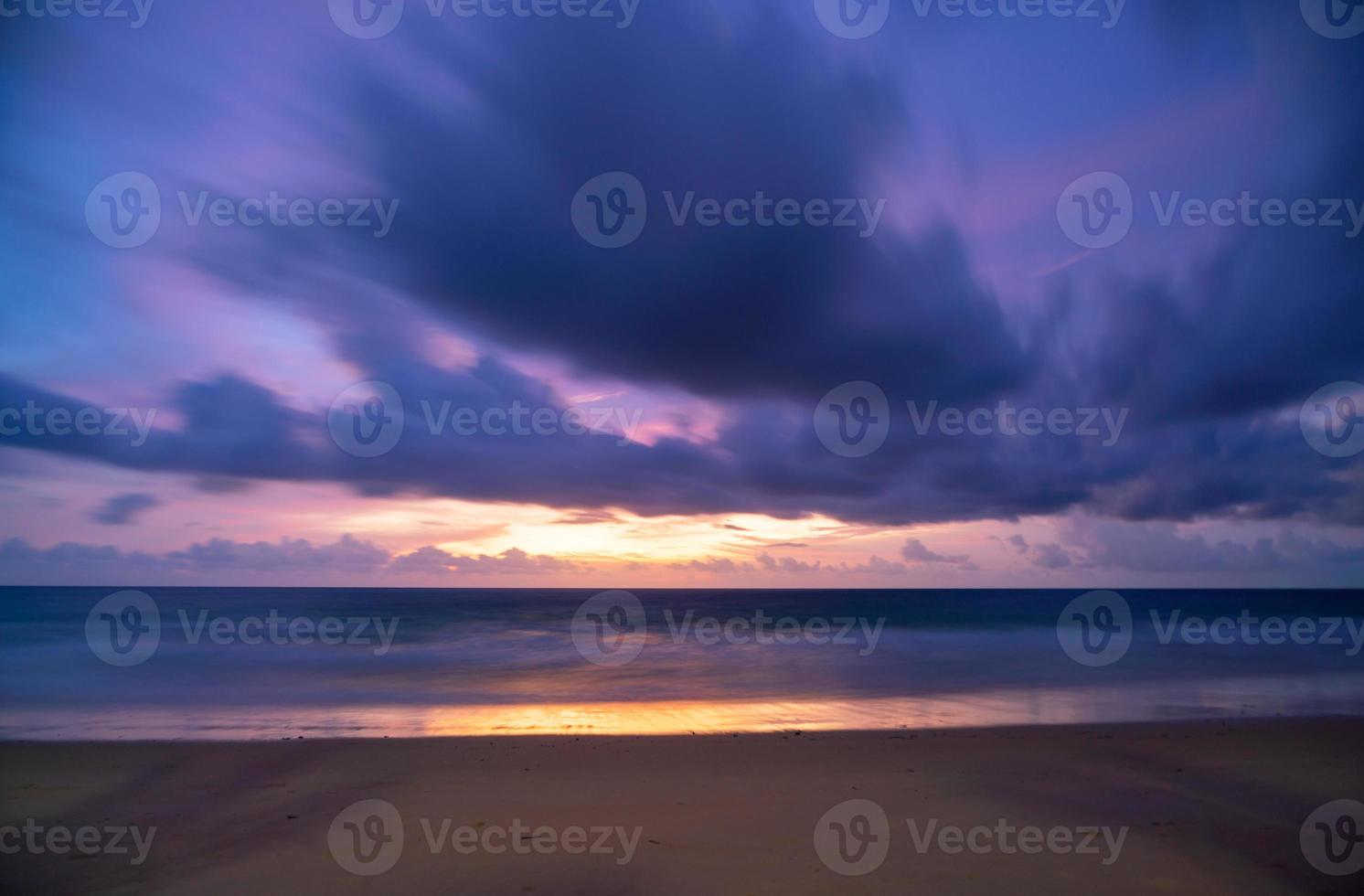 larga exposición cielo colorido puesta de sol o amanecer cielo colorido ardiente y olas brillantes rompiendo en la orilla arenosa hermosa reflexión de la luz en la superficie del mar increíble paisaje o paisaje marino fondo de la naturaleza foto