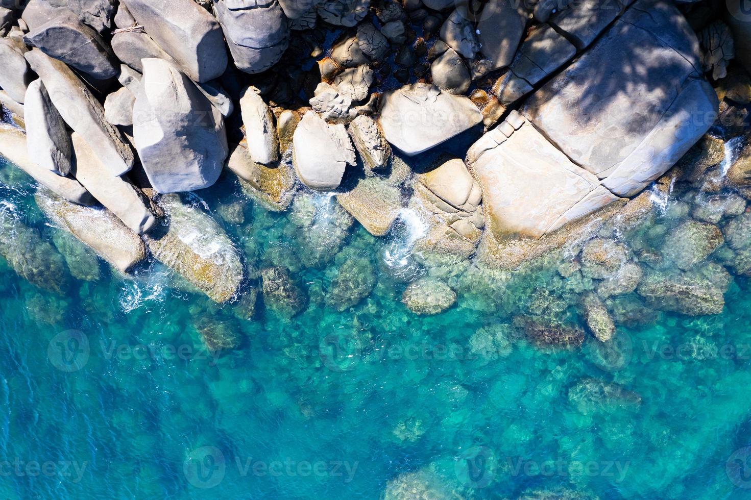 vista aérea de arriba hacia abajo rocas de la orilla del mar superficie del mar en un día soleado día de buen tiempo fondo de verano foto