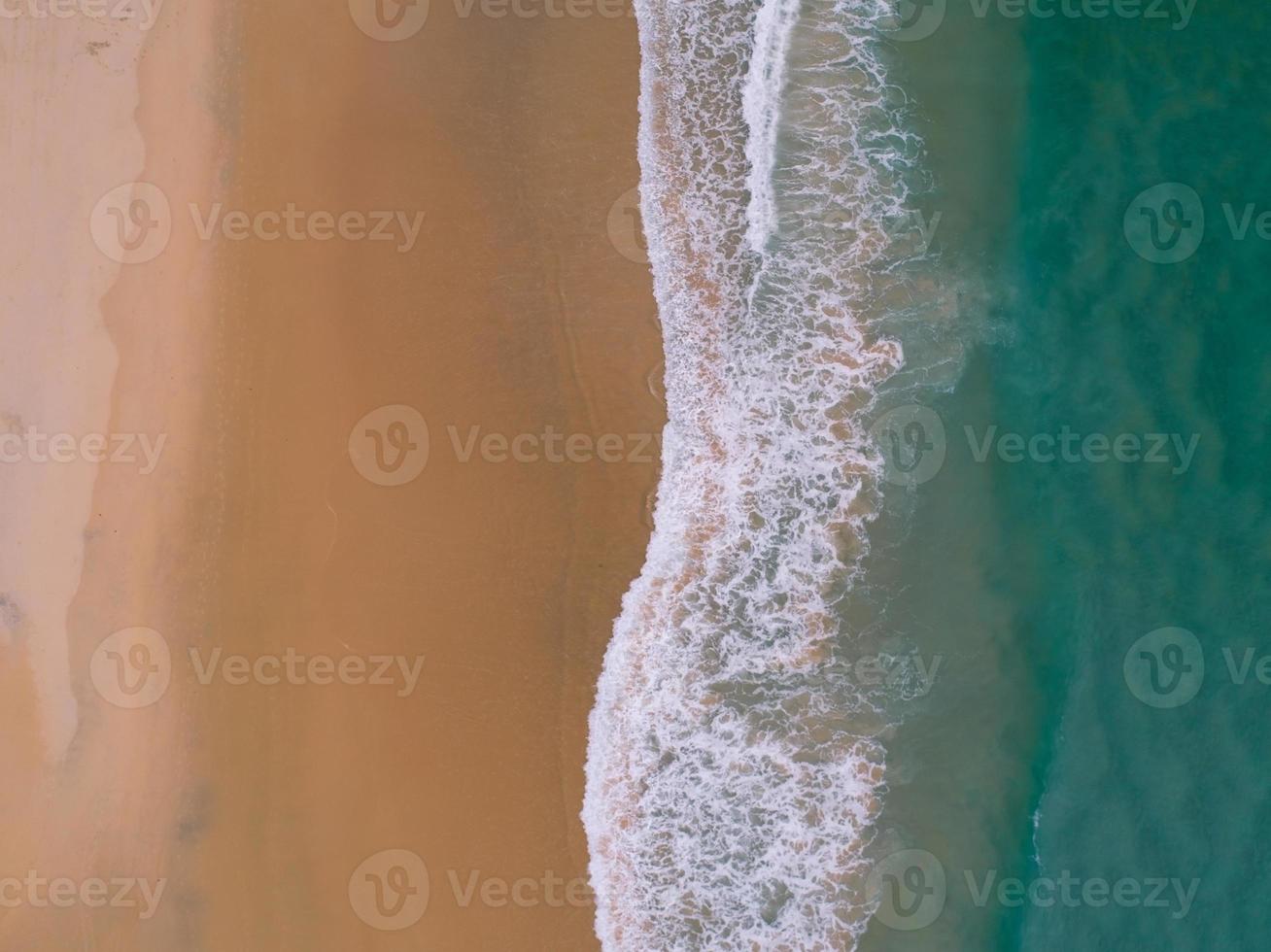 vista aérea playa de arena y olas hermoso mar tropical en la mañana imagen de la temporada de verano por vista aérea toma de drones, vista de ángulo alto de arriba hacia abajo olas del mar foto