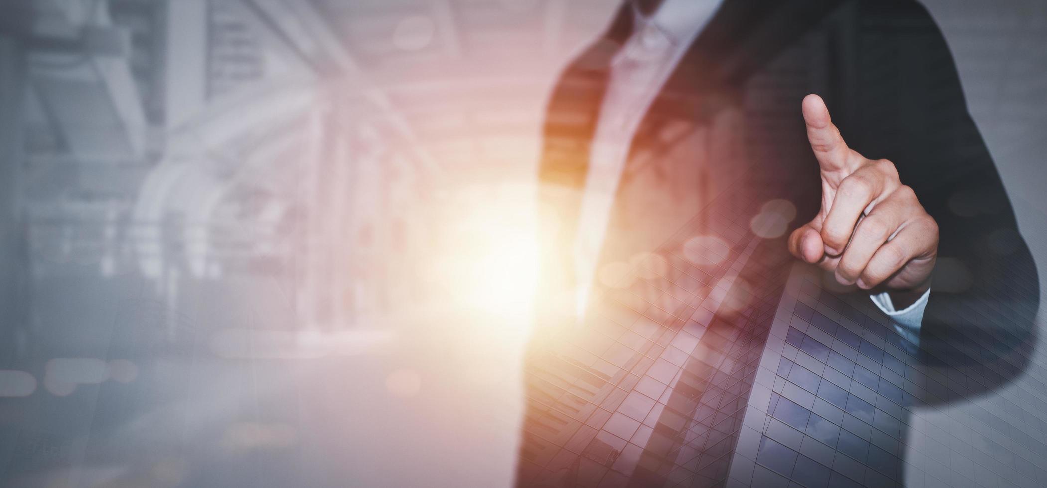 The double exposure image of the business man Raising the index finger, the sun shining bright in the middle of the picture with cityscapes, The concept business city life and internet of things. photo