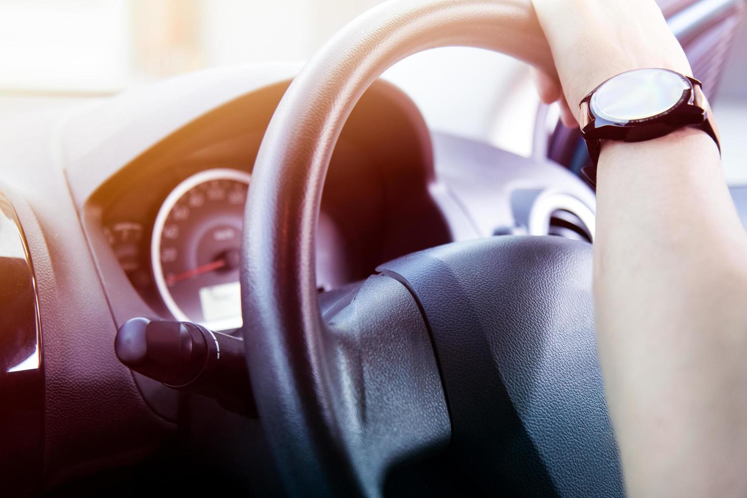 man driving car, there is sunlight shining in the front of the car. photo