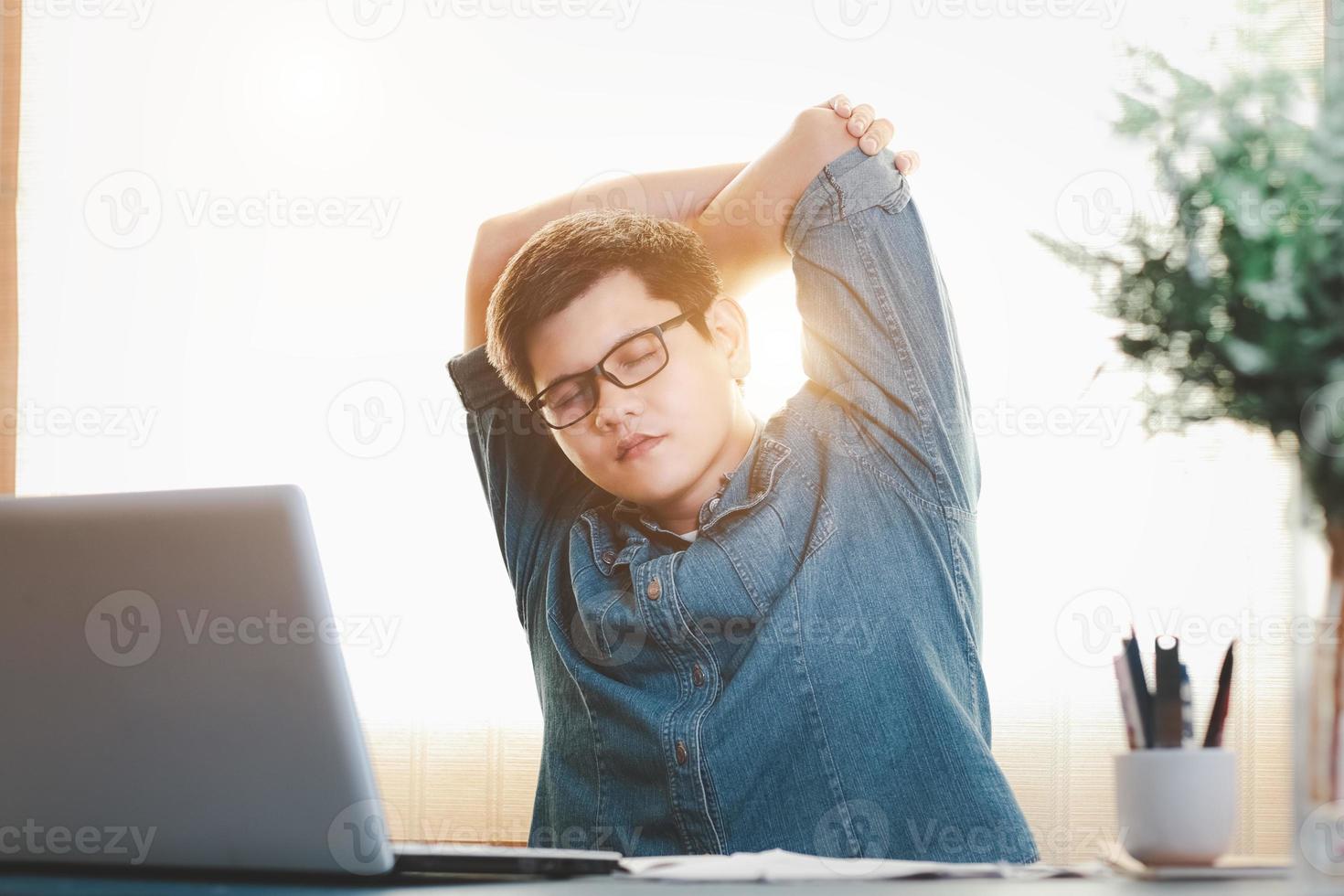 young businessman exercises stretching the muscles at the desk at work, Relax from hard work. photo