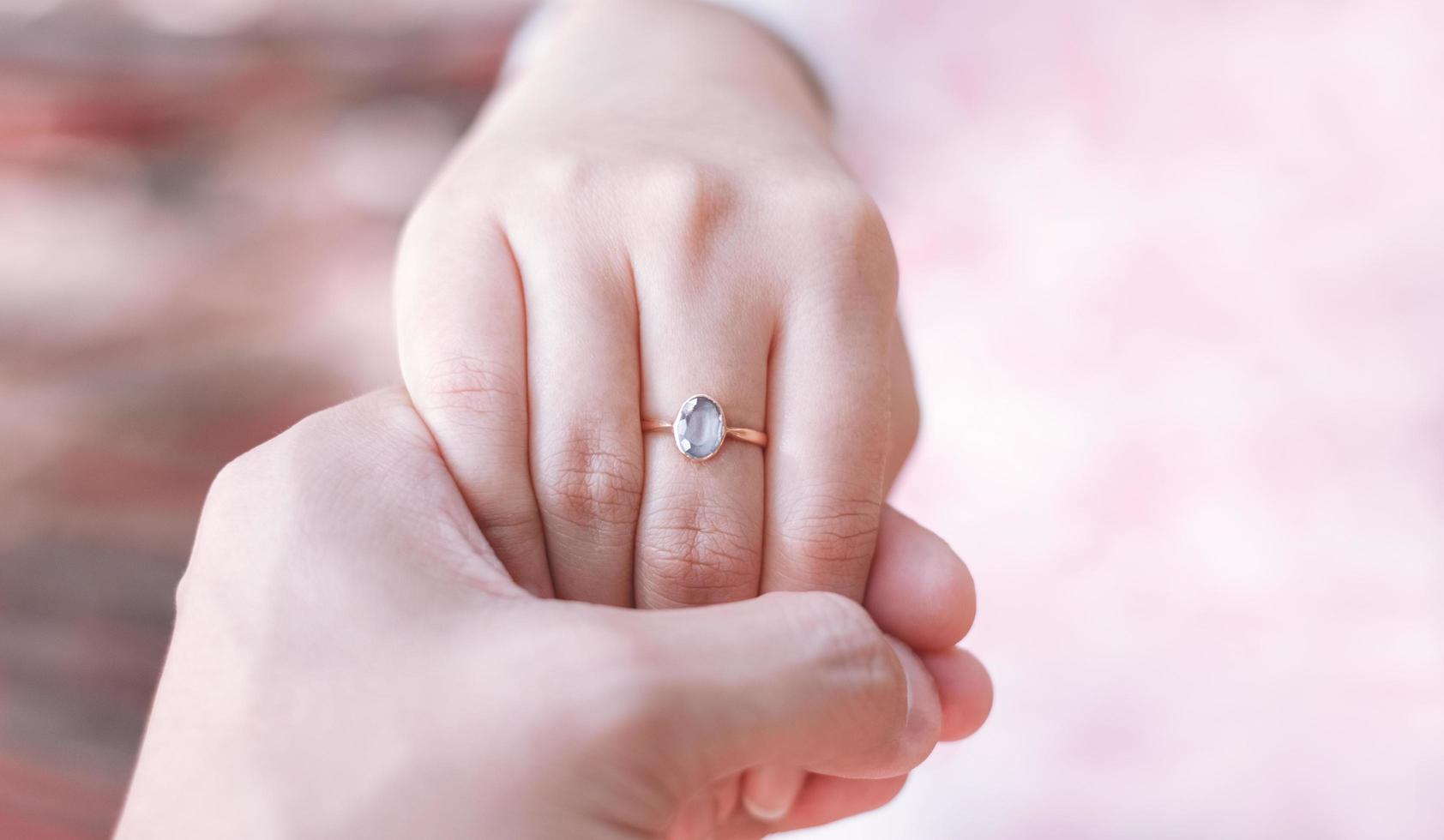 manos de hombres y mujeres con anillos de boda, tono rosa. foto