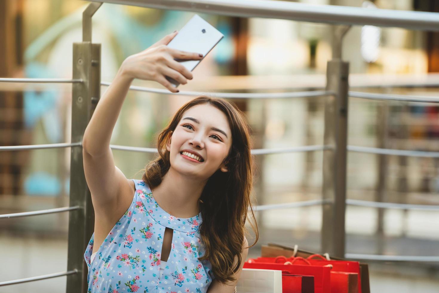 asia joven selfie con bolsas de compras foto