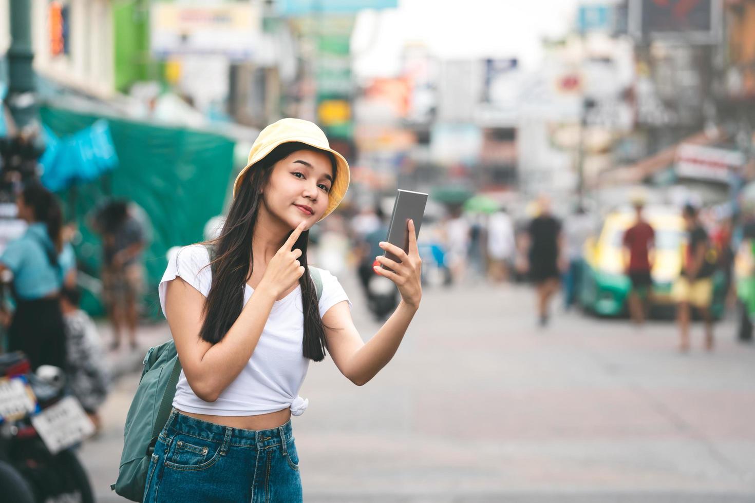 Asian traveller woman relax journey with smartphone in Bangkok city. photo