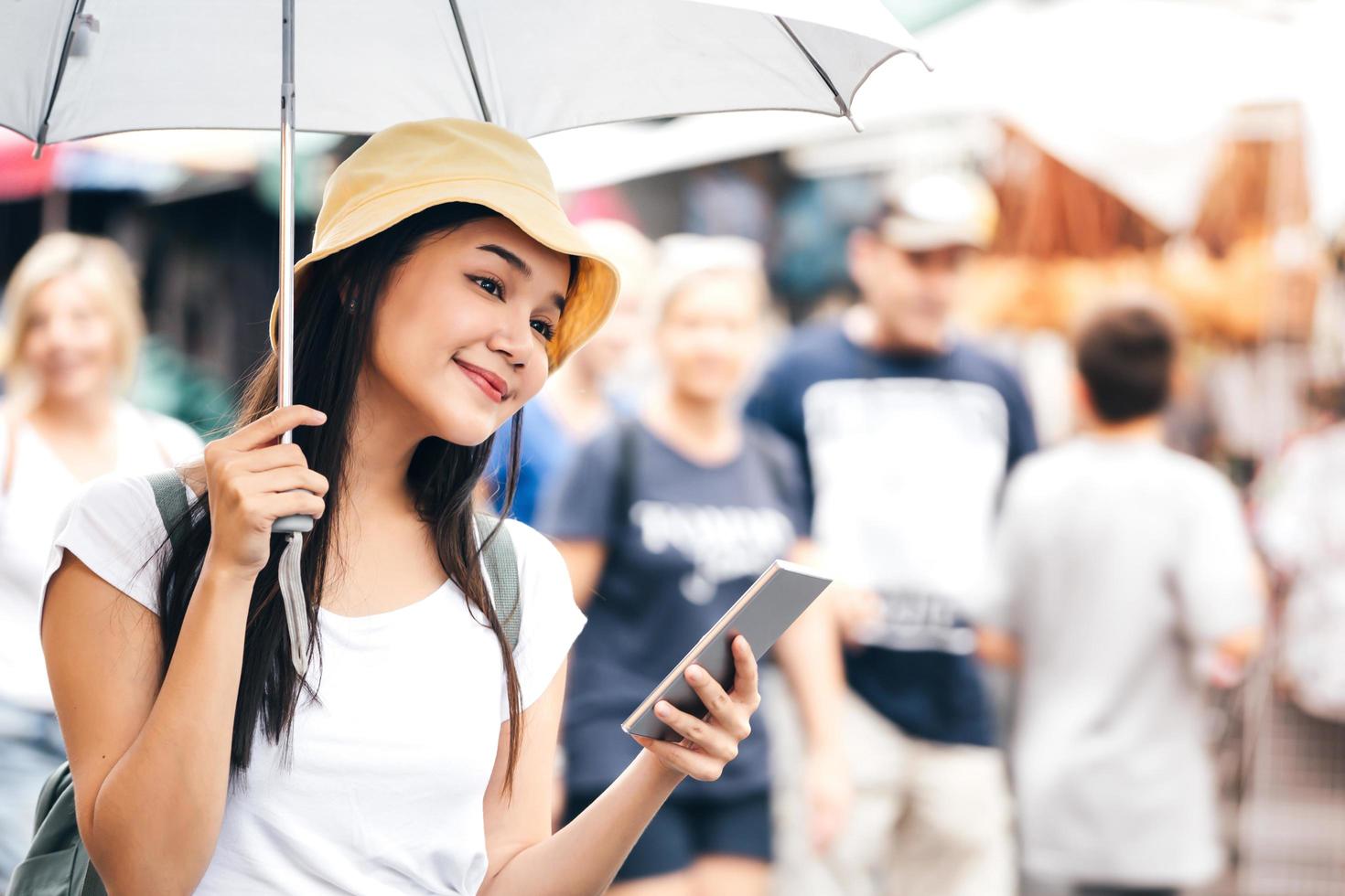 Young asia adult woman with umbrella use smart phone. photo