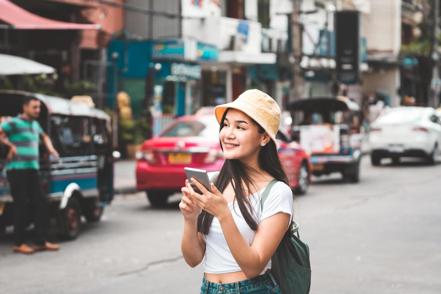 Asian traveller woman relax journey with smartphone in Bangkok city. photo