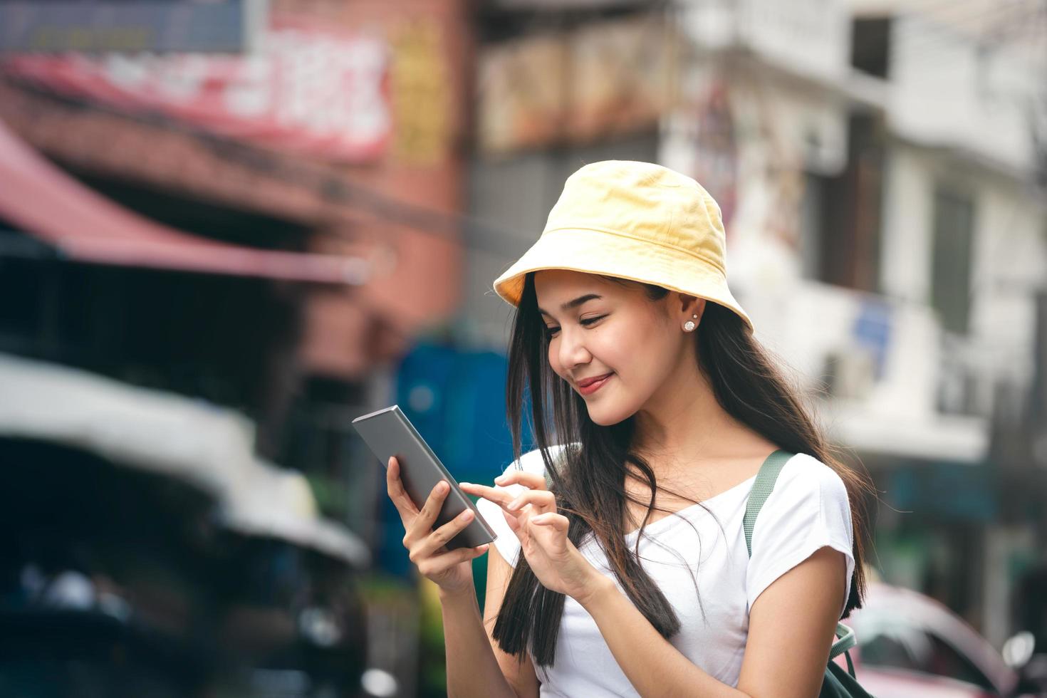 mujer viajera asiática relajarse viaje con teléfono inteligente en la ciudad de bangkok. foto