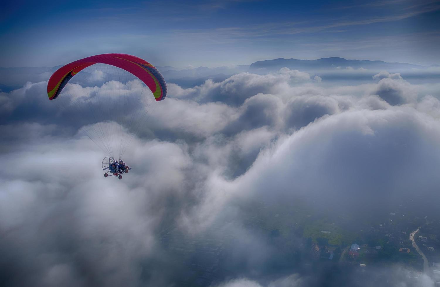 Para-motor flying above the white puffy cloud. Challenging anf freedom concept. photo