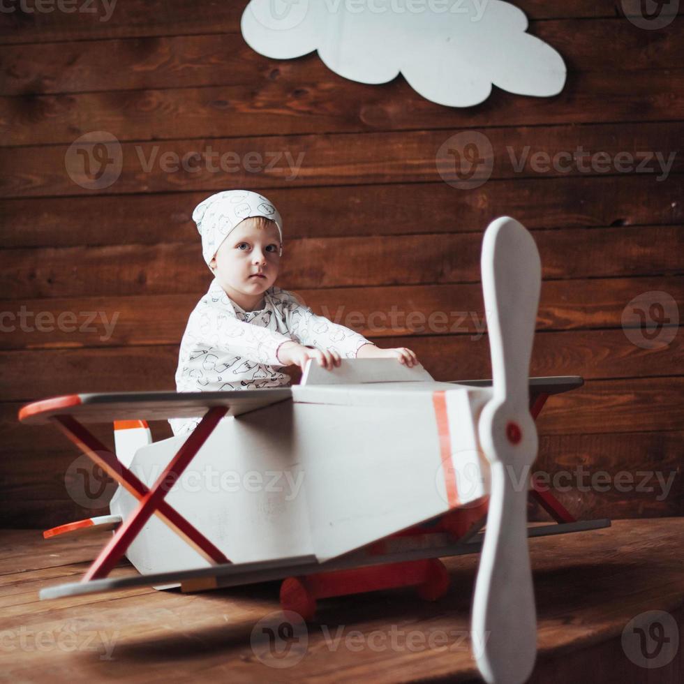 kid playing with wooden airplane photo
