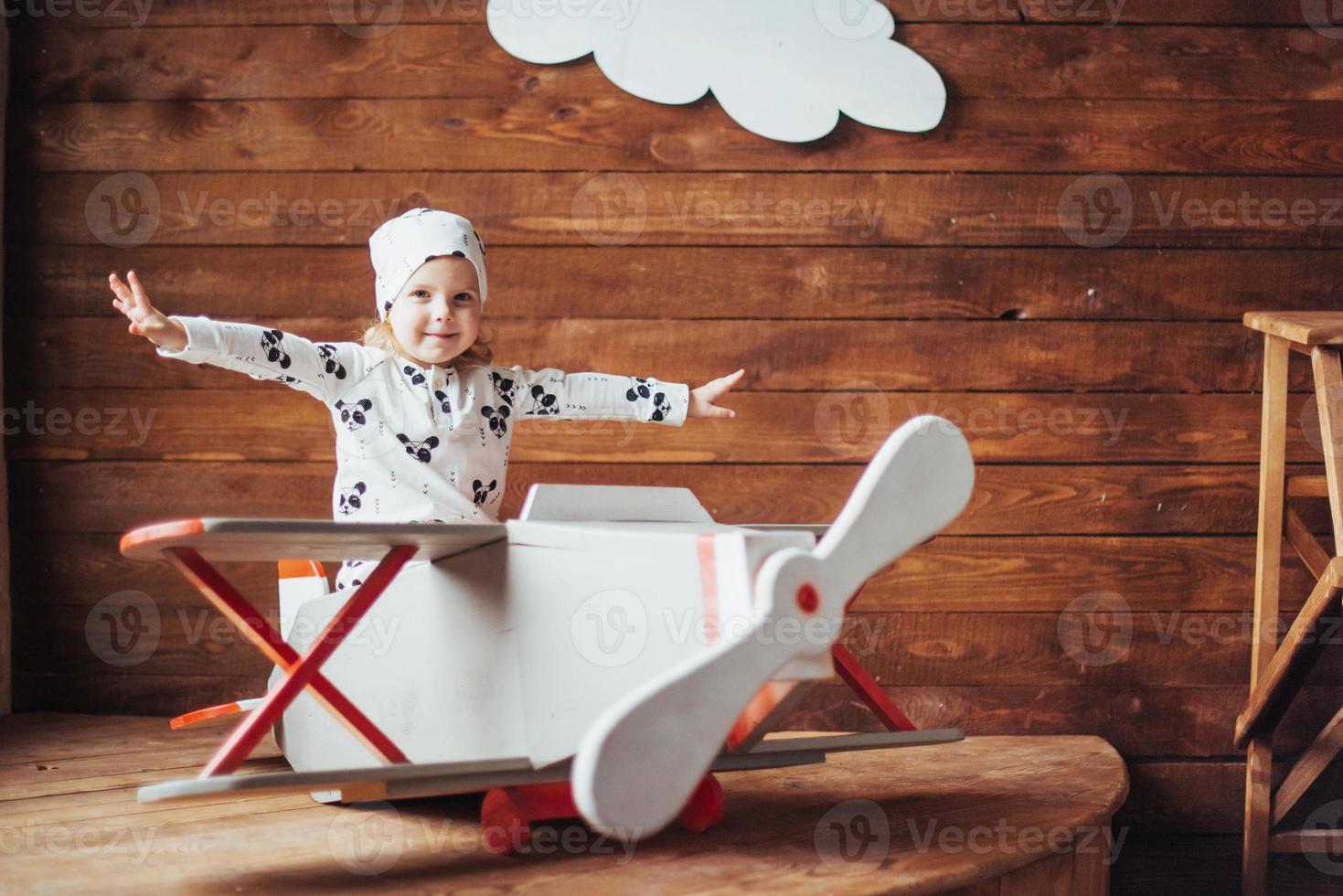 kid playing with wooden airplane photo