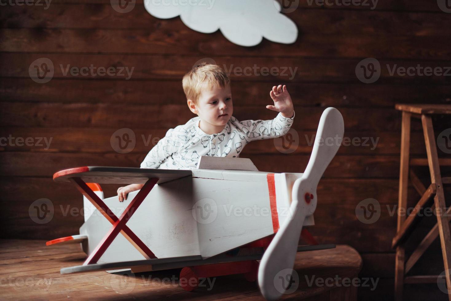 kid playing with wooden airplane photo