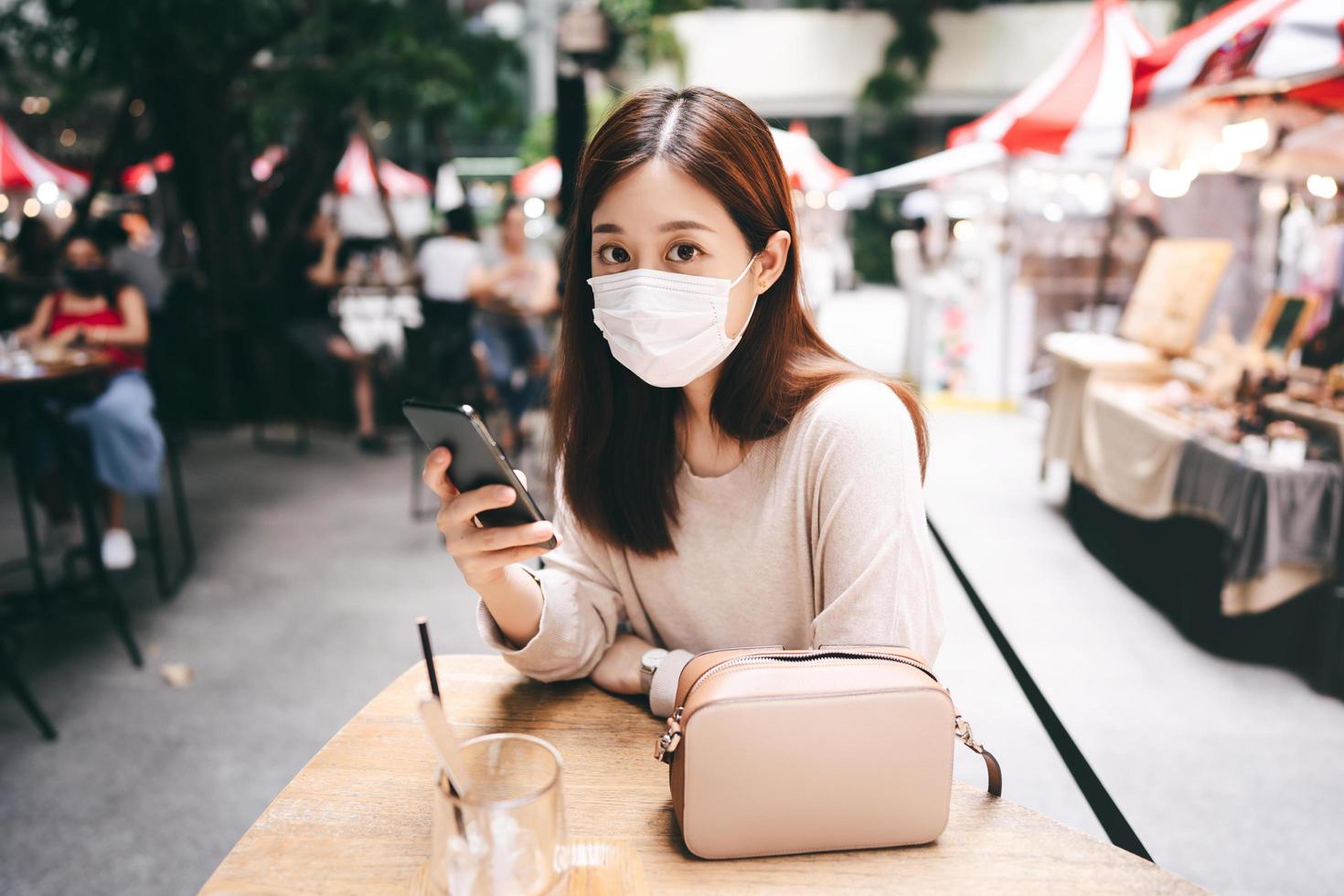 una mujer asiática adulta joven usa una máscara para un nuevo estilo de vida normal que la protege del virus de la corona foto