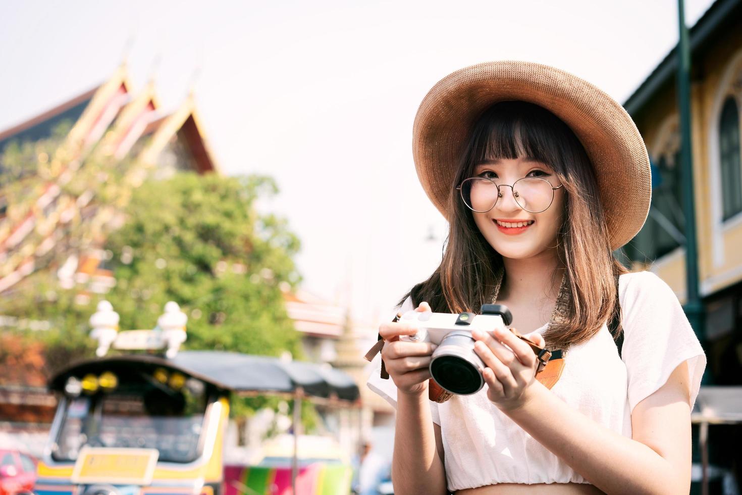 Young adult asian travel woman with camera background with famous destination photo