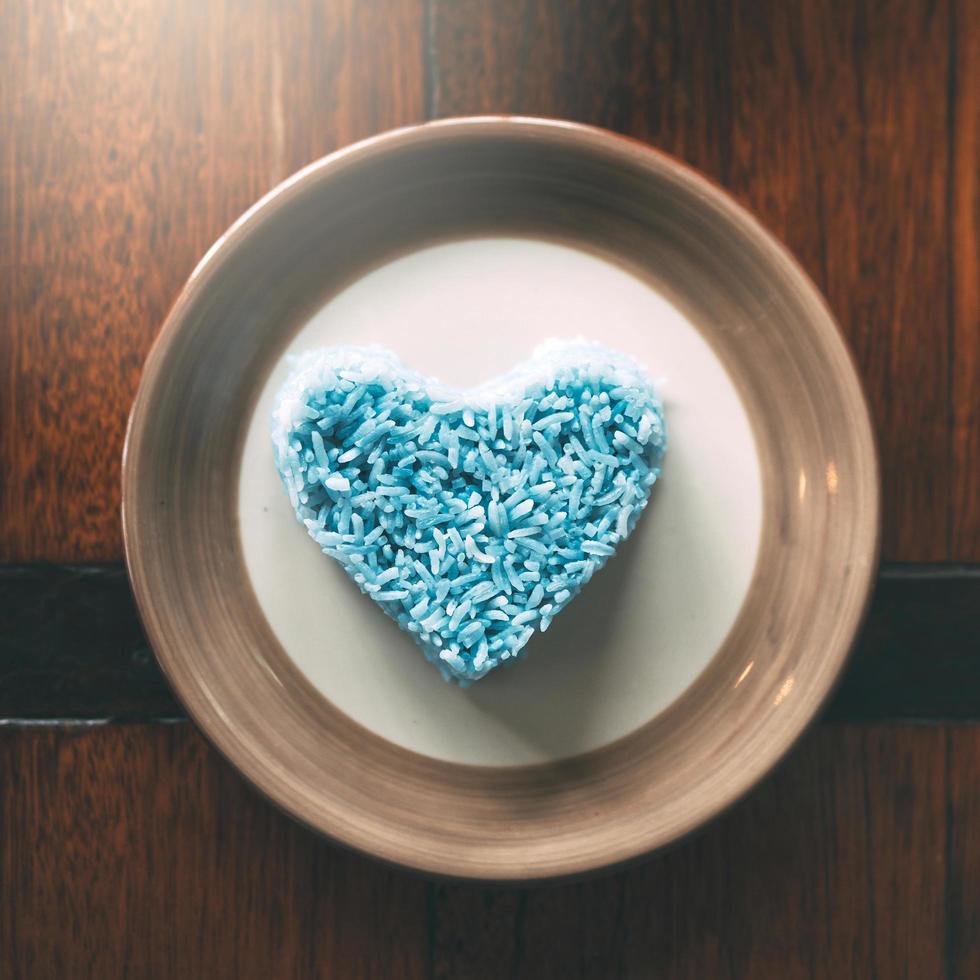 Cooked white rice with herb in blue color place on wooden table. photo