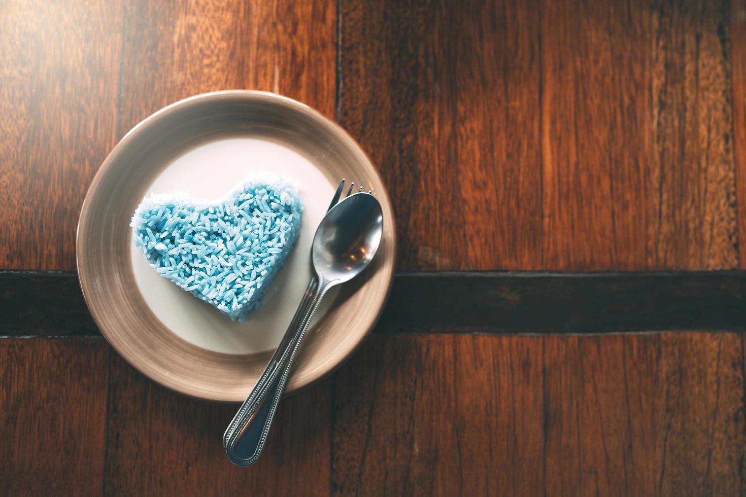 Cooked white rice with herb in blue color place on wooden table. photo