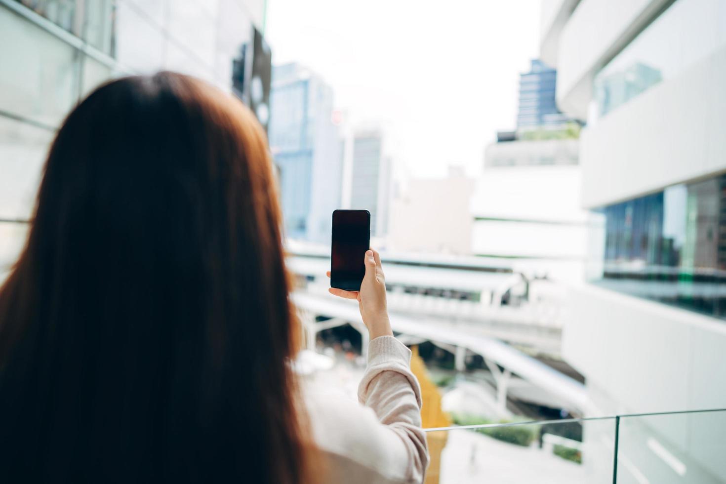 Shoulder view of woman holding mobile phone empty screen photo