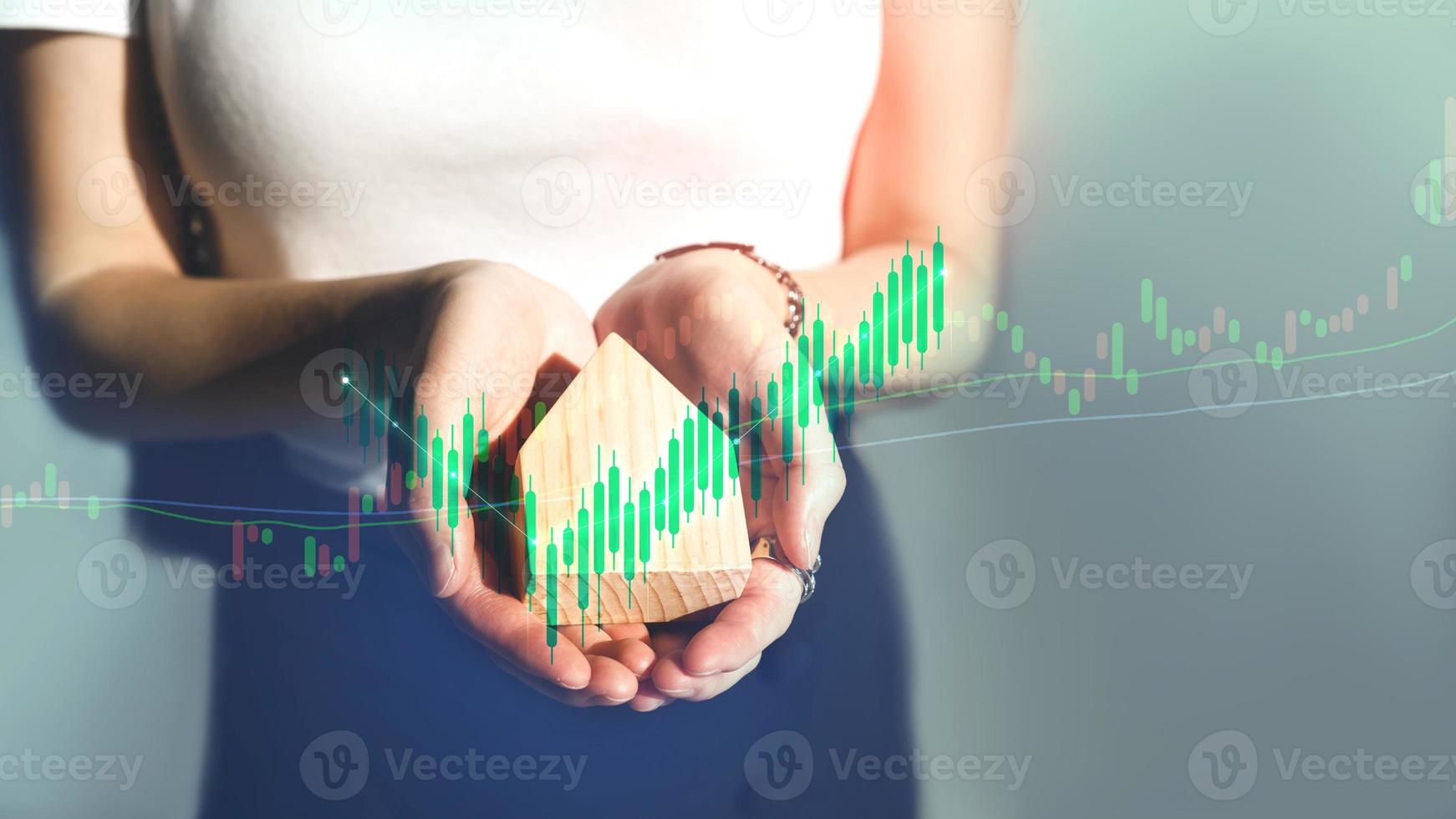 Business working woman hand holding home model with digital finance graph. photo