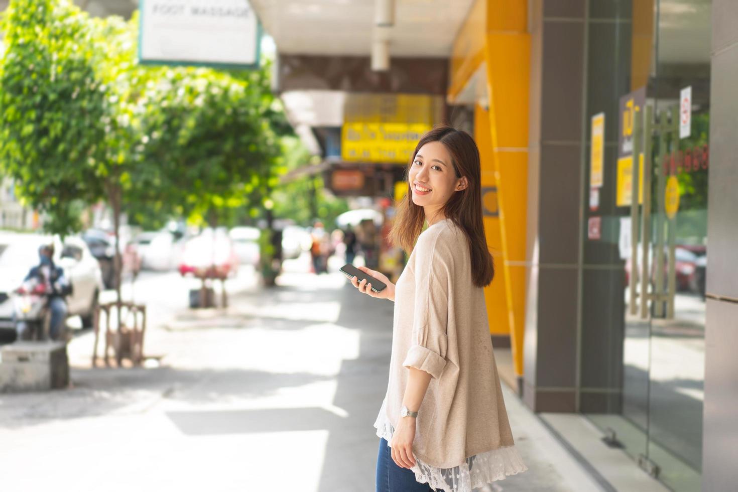 mujer asiática de negocios adultos jóvenes caminando en público al aire libre. foto