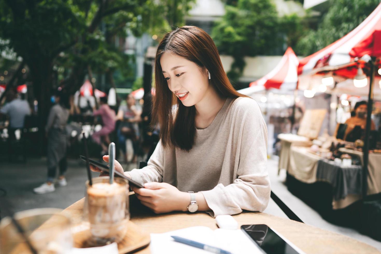 Young adult business asian woman use tablet for business at outdoor cafe photo