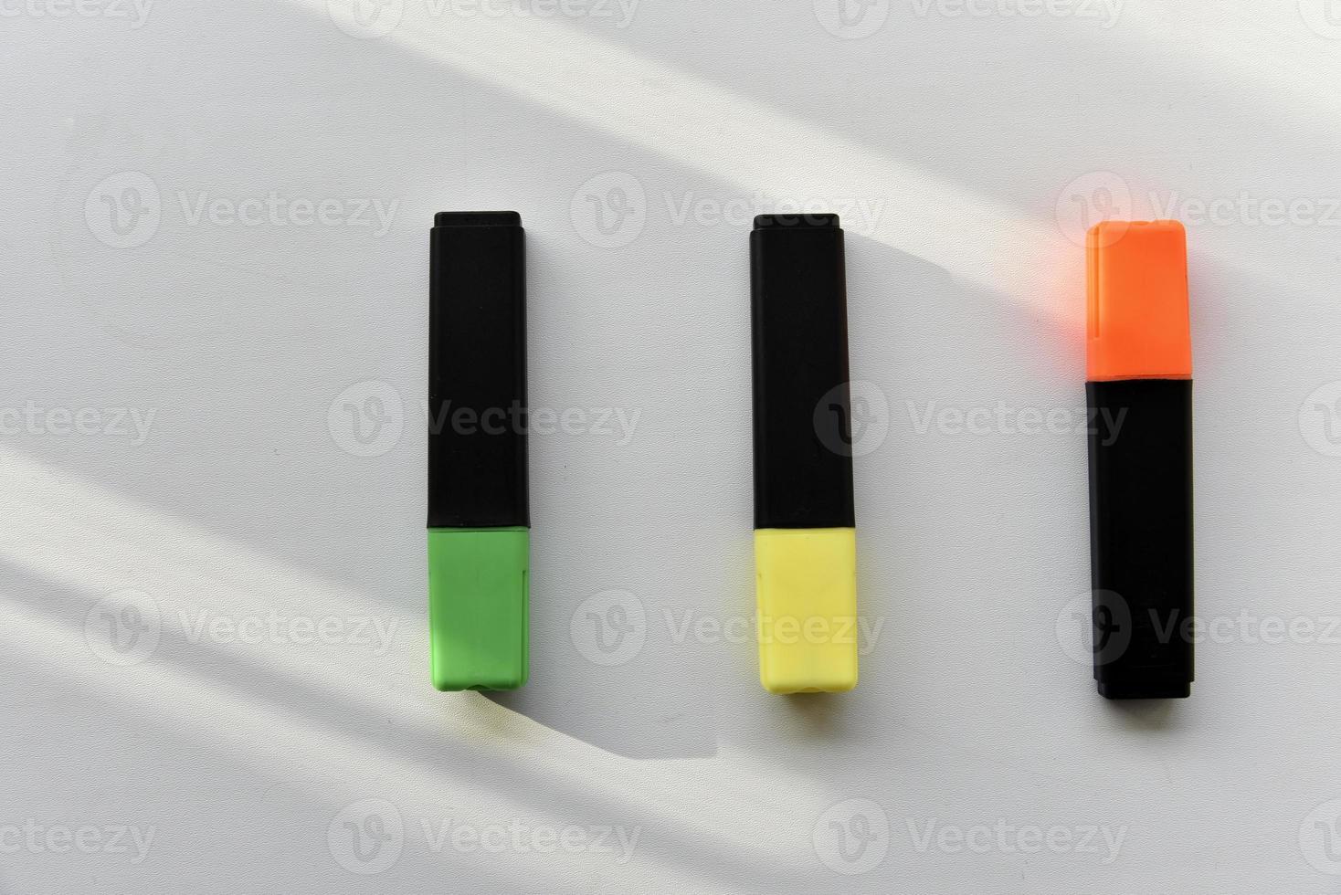 Colored markers on a white background in the light photo